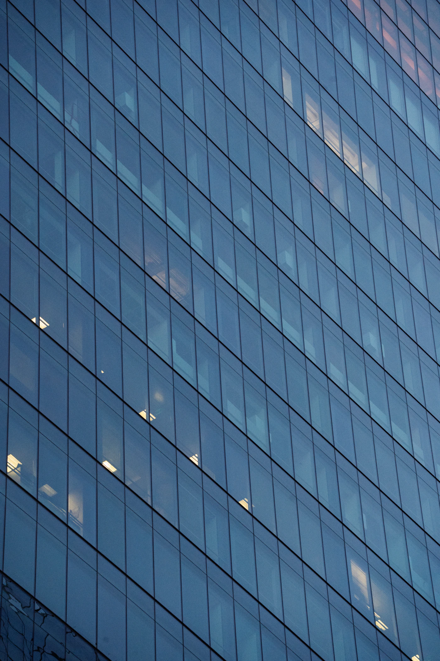 Modern glass office building reflecting the sky